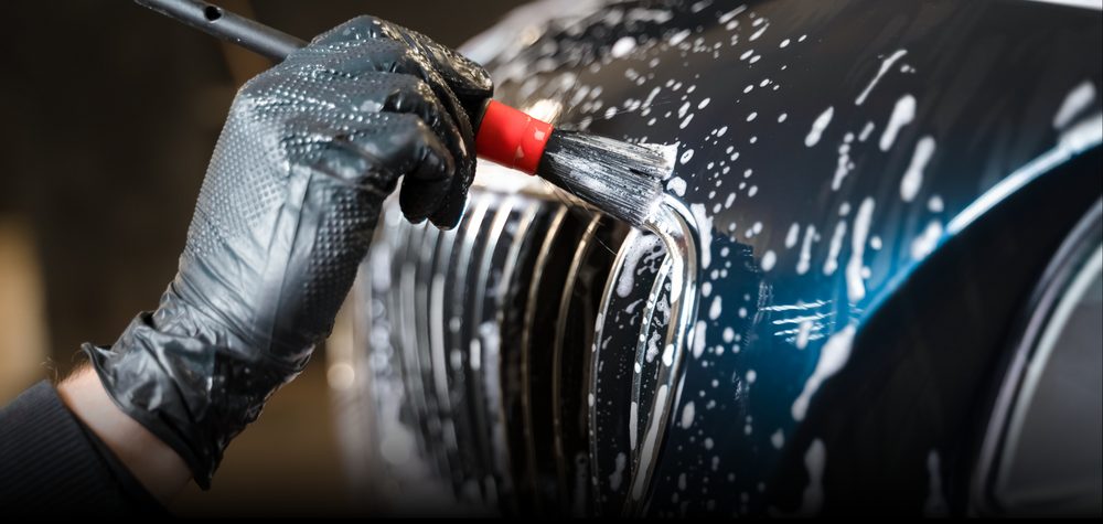 Hand-washing a vehicle grille with a detail brush